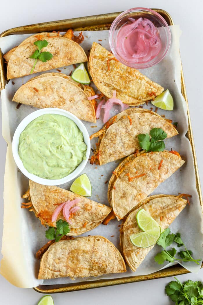 These crispy chicken tacos are so delicious and so easy to make! Pair them with an avocado crema and you have the perfect weeknight meal or game day appetizer.
