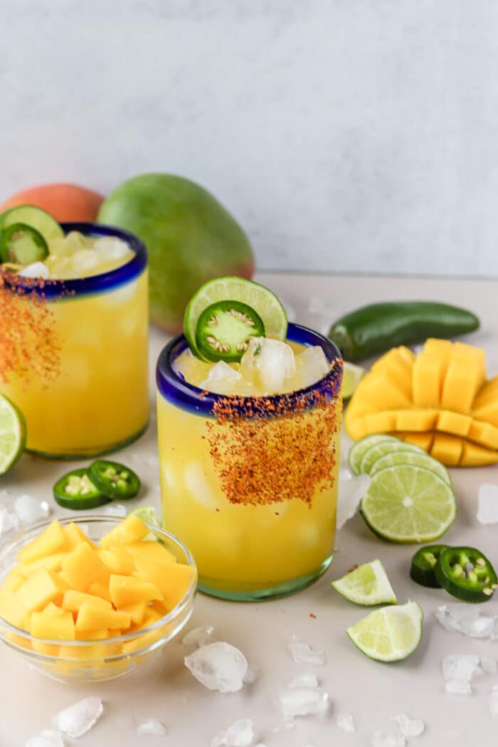 This spicy mango margarita on the rocks is such a refreshing twist on a classic margarita recipe. It's the perfect combination of sweet and spicy, with a few simple ingredients it comes together so easily. Let's make it!