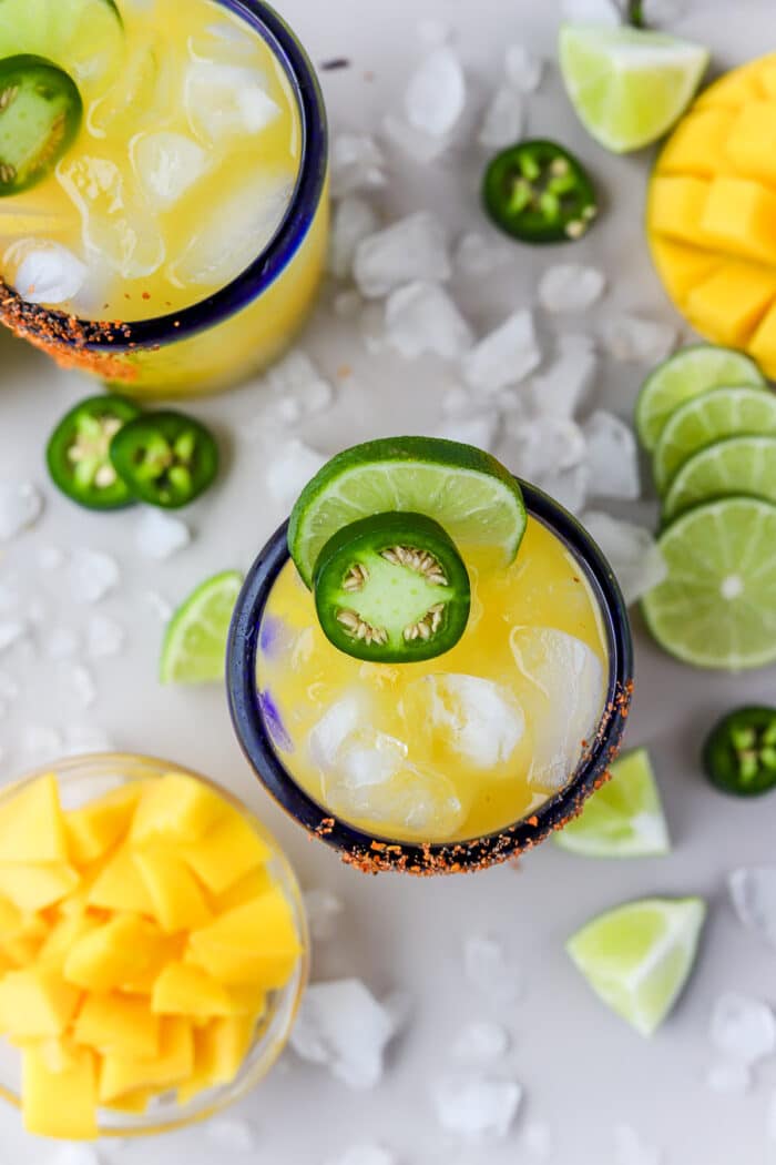 This spicy mango margarita on the rocks is such a refreshing twist on a classic margarita recipe. It's the perfect combination of sweet and spicy, with a few simple ingredients it comes together so easily. Let's make it!