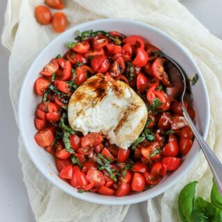 This burrata caprese appetizer is so simple, and so delicious. The creamy burrata cheese on top of marinated fresh tomatoes topped with fresh basil leaves and a balsamic reduction will be your new favorite recipe!